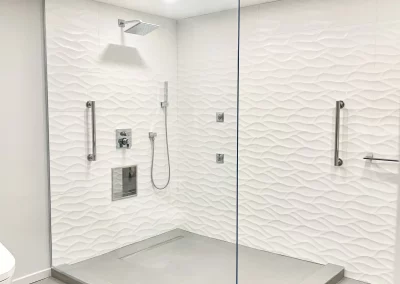 Image of white shower area with frameless spray panel from Shower Door King.