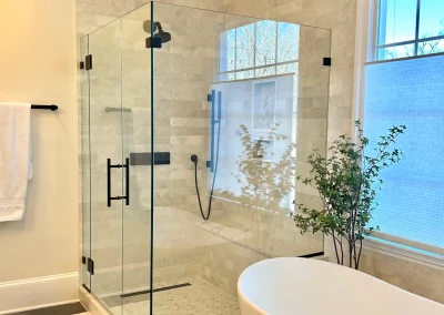 Image of gray and white shower area with contemporary frameless panel door panel and return from Shower Door King.