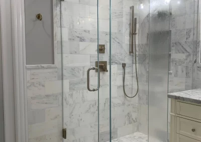 Image of gray shower area with custom frameless enclosure from Shower Door King.
