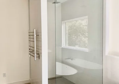 Image of white shower with frameless spray panel and wall from Shower Door King.